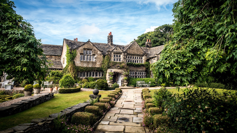 front view of Holdsworth House Hotel a Jacobean manor house with stone mullion windows and traditional Yorkshire stone roof gables.  